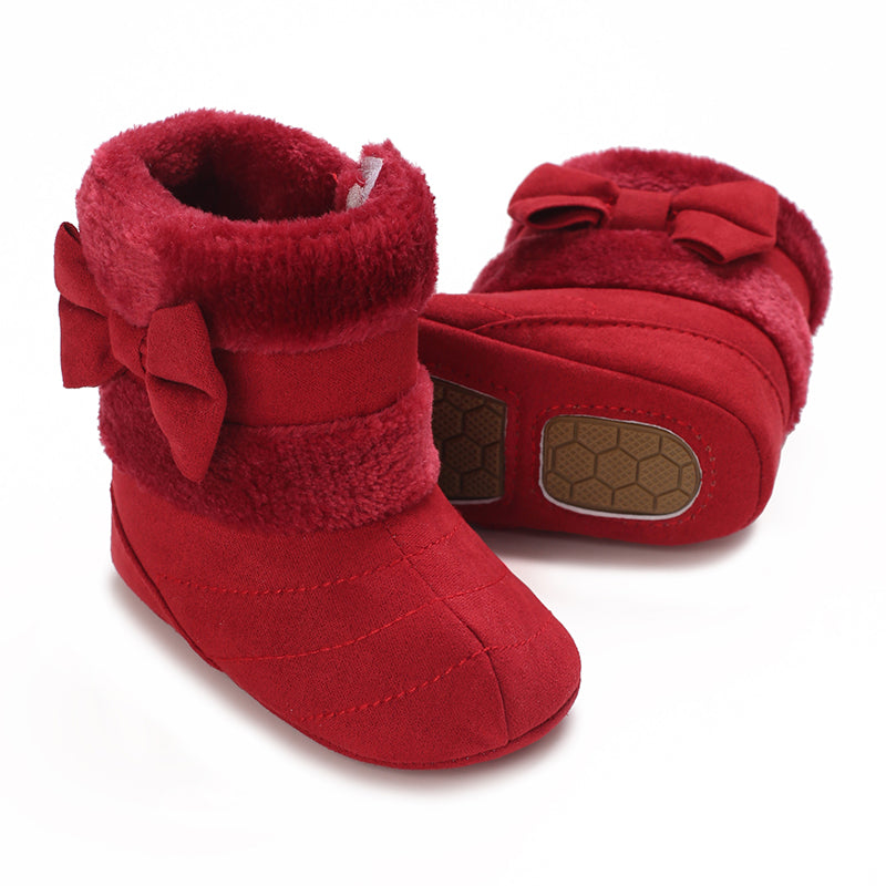 Deep red baby boots with side bows, plush cuffs and a textured sole shown