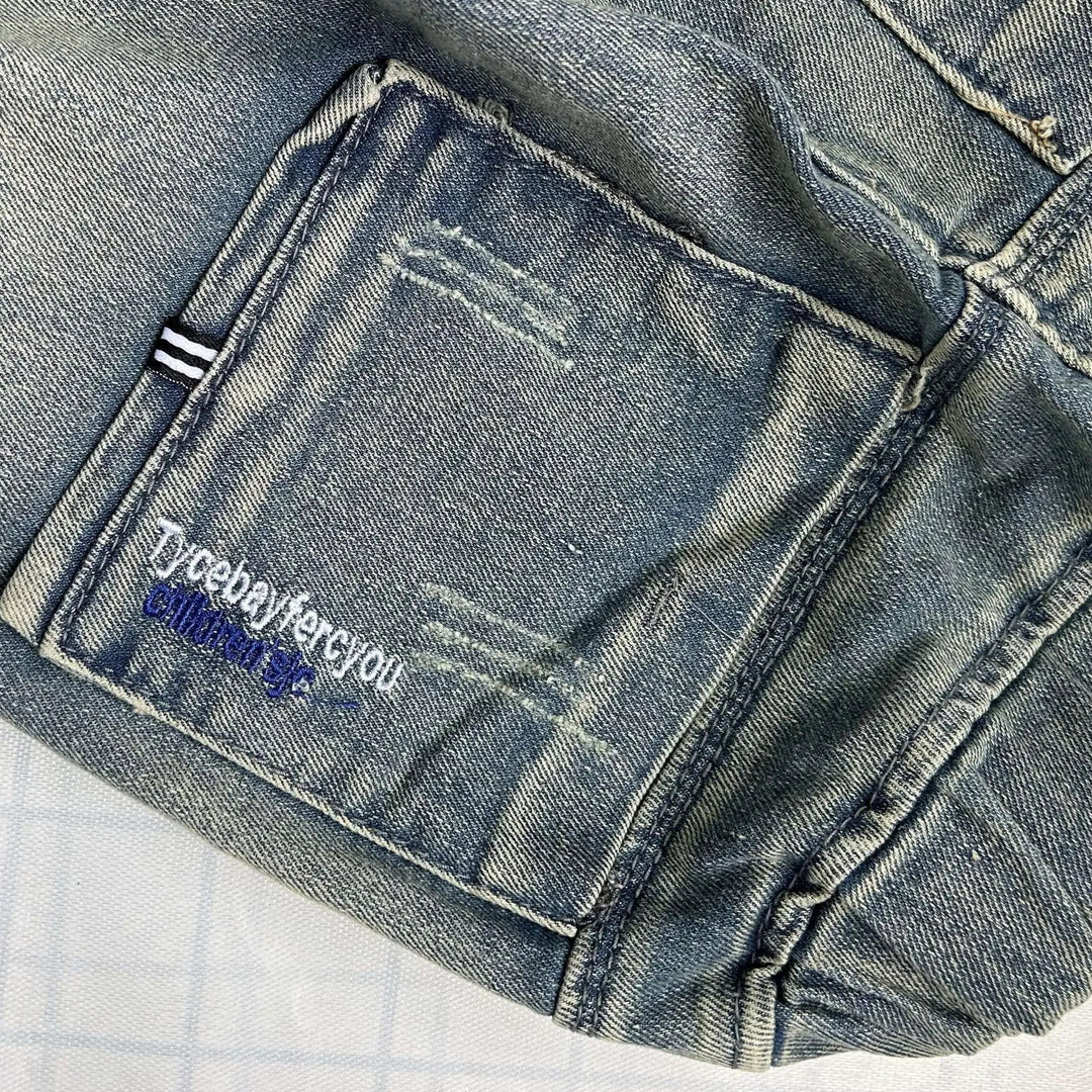 Close-up of a denim back pocket with contrast stitching and faded detailing.