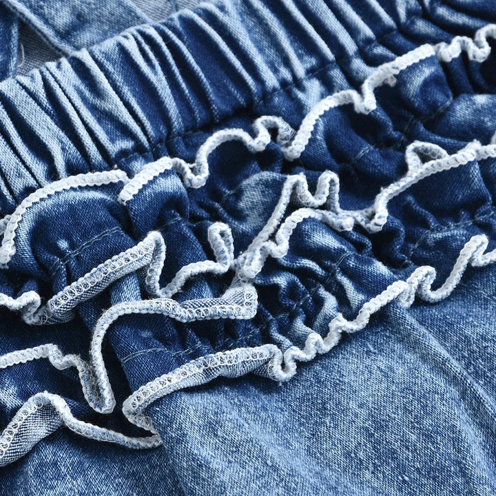 Close-up of denim back ruffles with light-colored edging beneath a gathered waistband