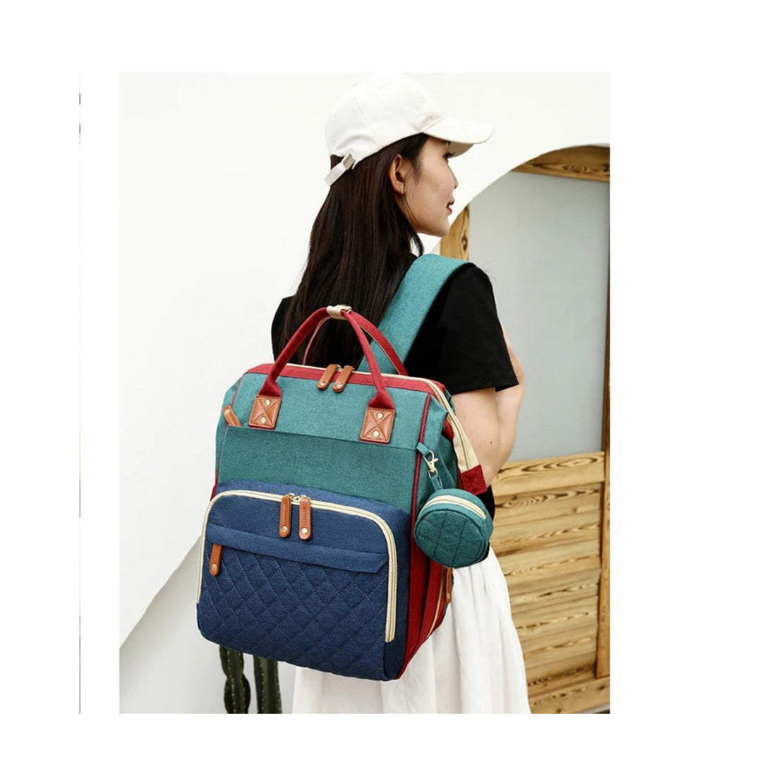 Woman wearing the blue-and-green diaper bag as a backpack