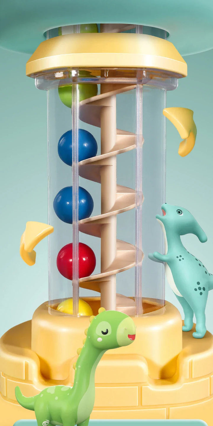 Close-up of the clear spiral tower with red and blue balls beside dinosaur decorations