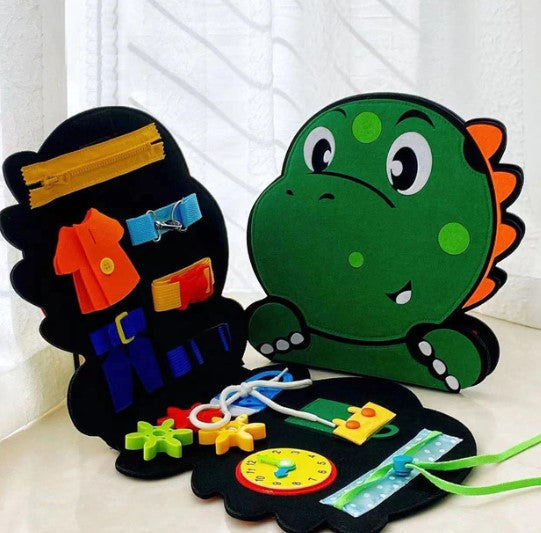 Open dinosaur felt busy board with zippers, colorful buckles, laces, gears, and a clock face.