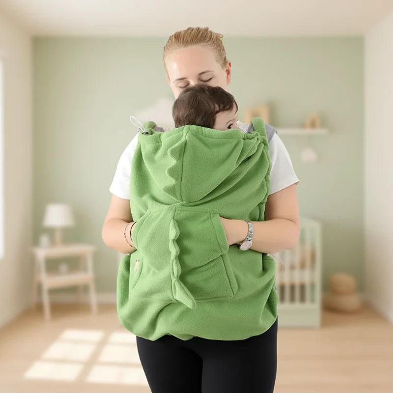 Front view of a green dinosaur carrier cover with the hood lowered and large pocket visible