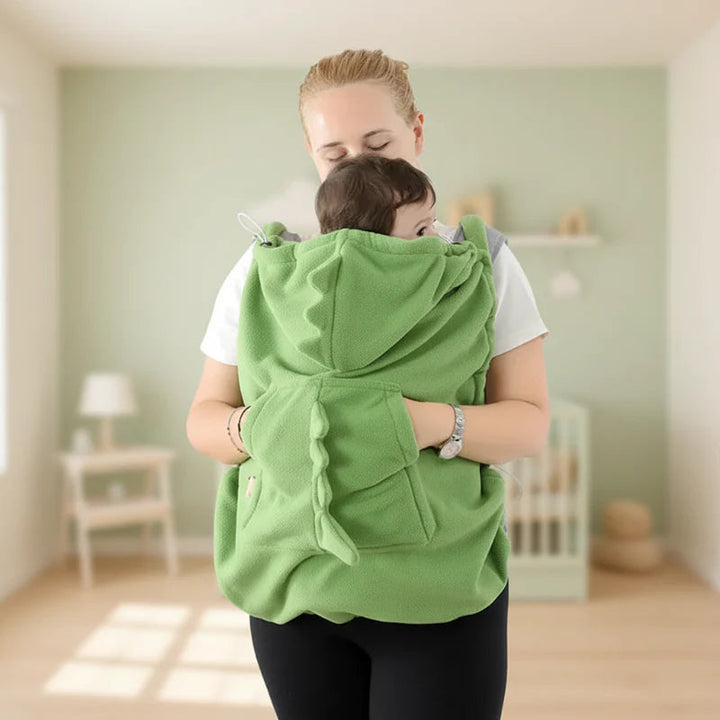 Front view of a green dinosaur carrier cover with the hood lowered and large pocket visible