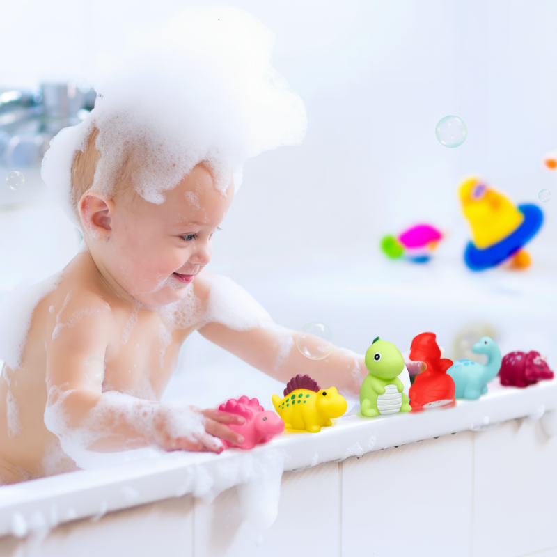 Child with bubbly hair lining up dinosaur bath toys along the tub edge