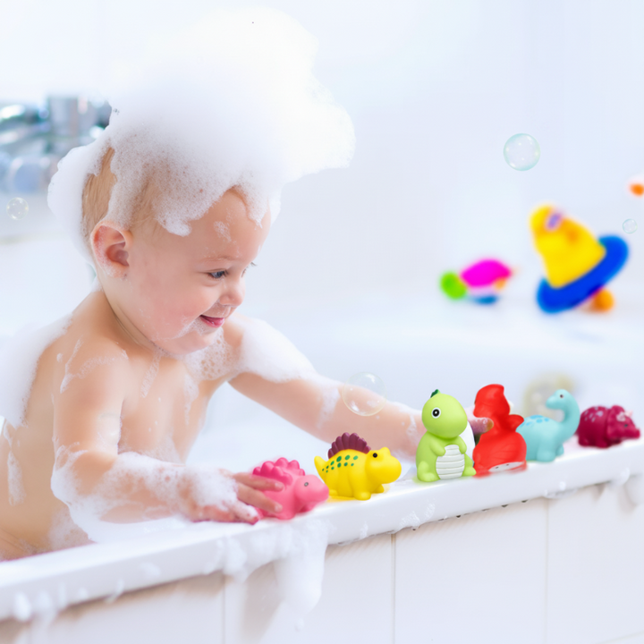 Child with bubbly hair lining up dinosaur bath toys along the tub edge