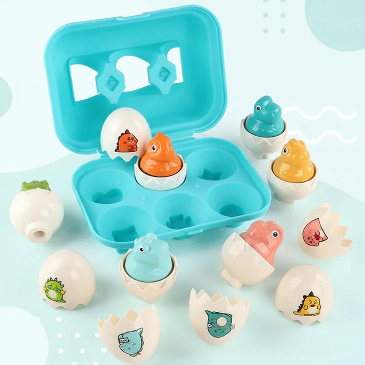 Colorful dinosaur figures in open white eggshells beside a turquoise storage case