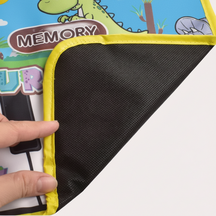 Corner of the dinosaur piano play mat lifted to show its textured black underside