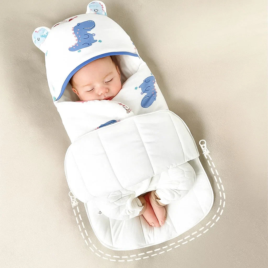 Baby in a dinosaur-print swaddle with a wide front panel and open lower section