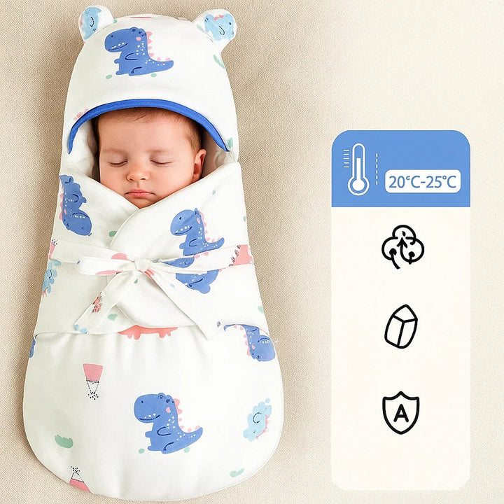 Baby wrapped in a dinosaur-print swaddle blanket with a rounded-ear hood