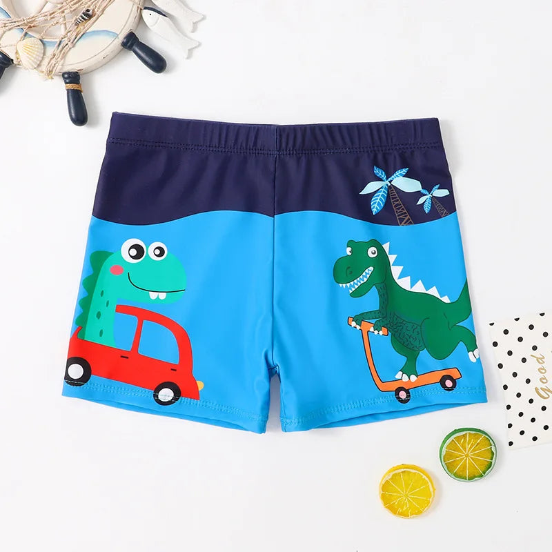 Blue and navy swim trunks with cartoon dinosaurs, a red car, and an orange scooter.