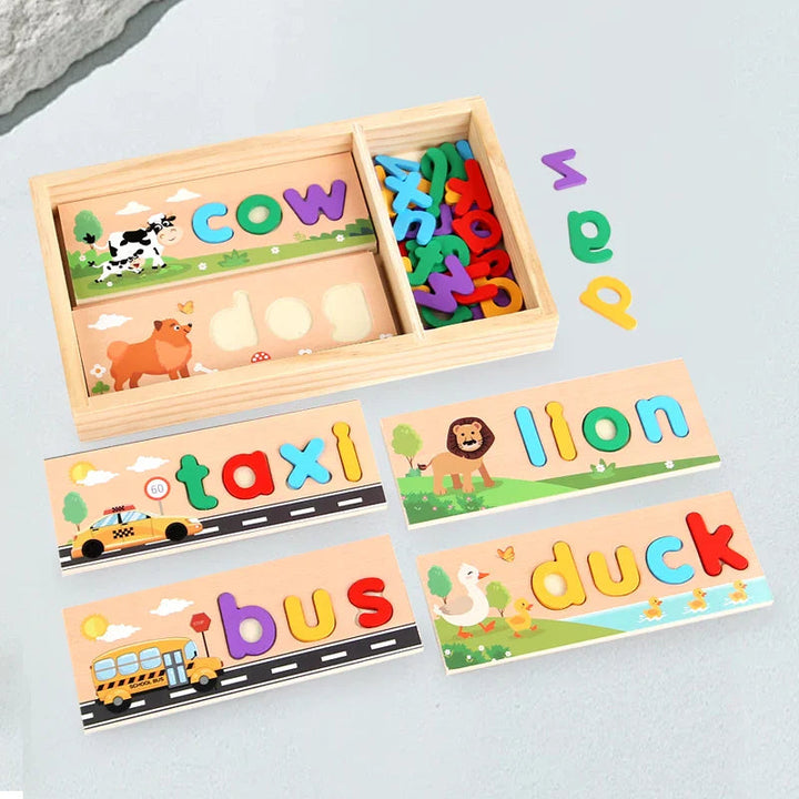 Wooden tray holding letter pieces and word boards, with taxi, lion, bus, and duck boards alongside