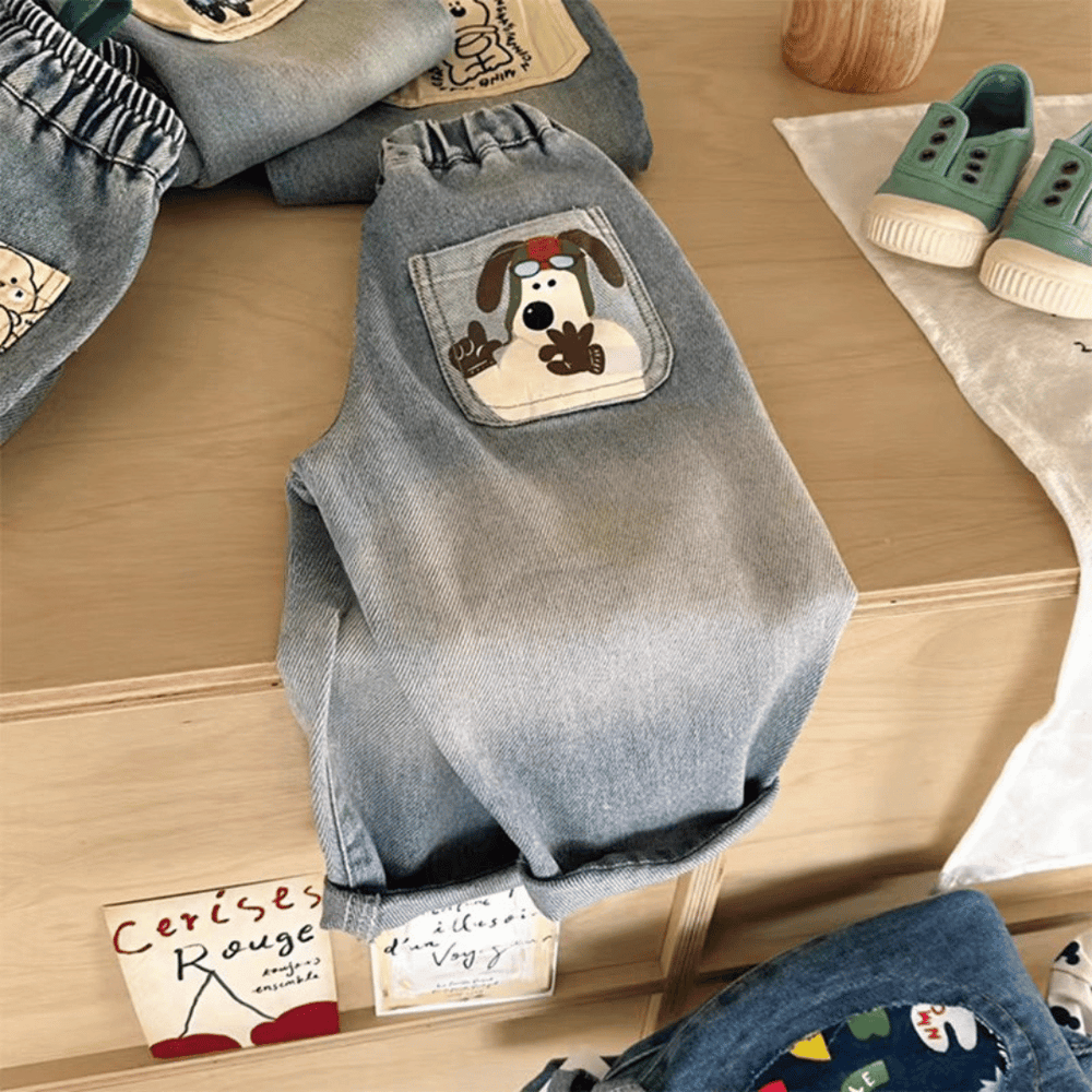 Blue children's jeans with a dog-print pocket and rolled cuffs