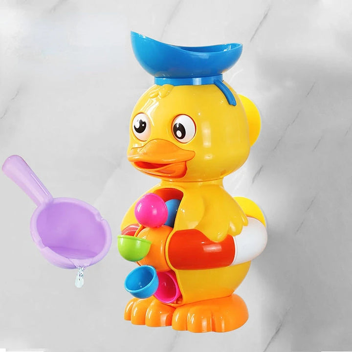 Side view of a yellow duck bath toy with a blue top bowl beside a purple scoop