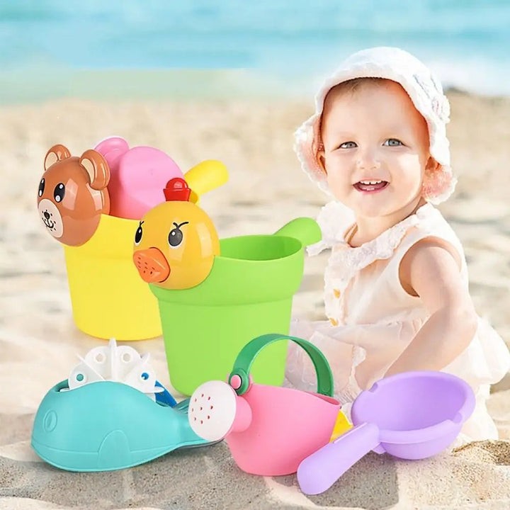 Child on the beach beside duck and bear buckets, a watering can, water wheel, and purple scoop