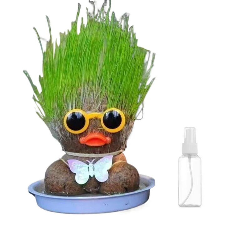 Duck-style grass figure in a blue bowl beside its included spray bottle