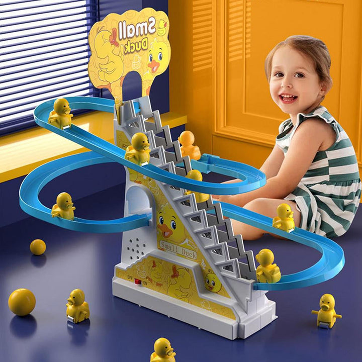 Child beside a duck slide toy with yellow ducklings, a blue track, and a central stairway.