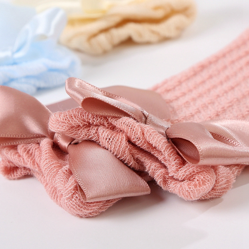 Close-up of dusty rose elastic sock cuffs and satin bows