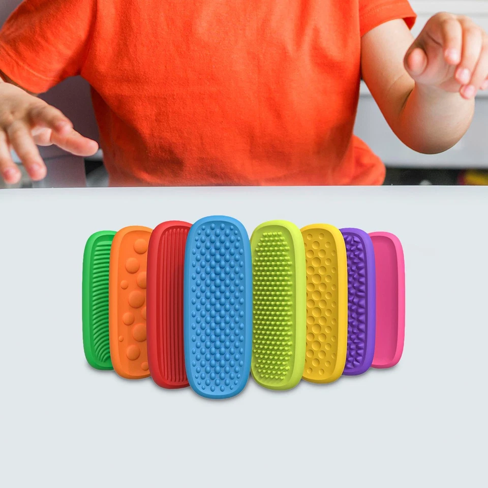 Child seated at a table behind a row of eight colorful sensory strips.