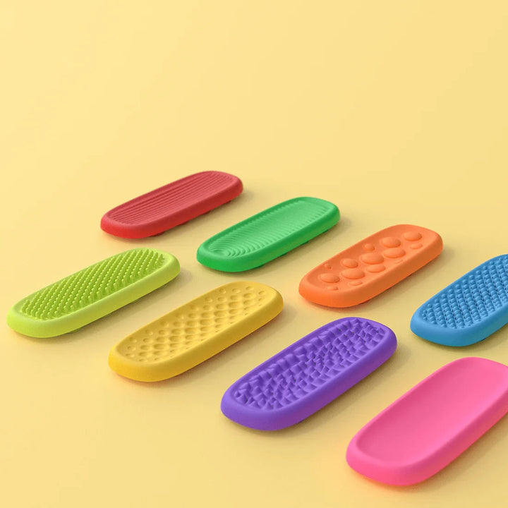 Eight colorful silicone sensory strips with varied raised patterns and one smooth pink surface.