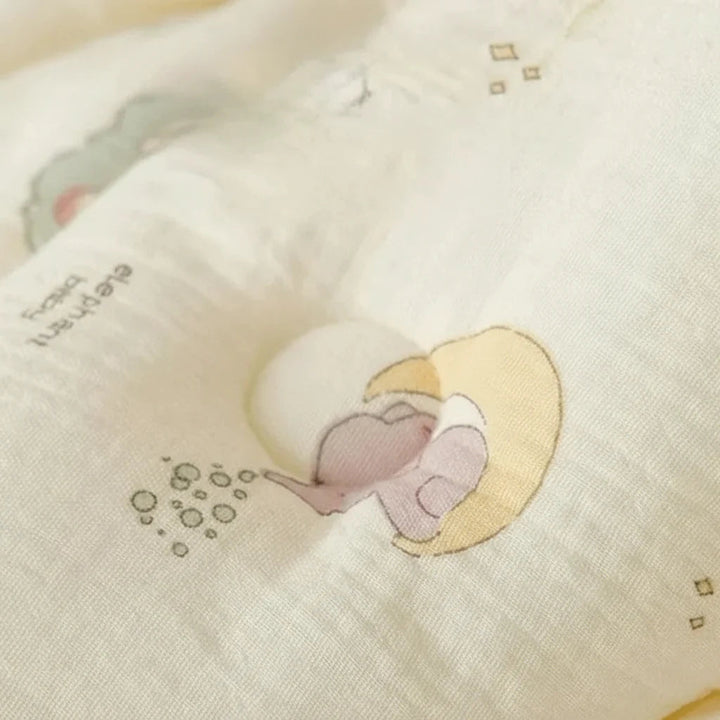 Close-up of cotton swaddle fabric with a pastel elephant resting on a crescent moon