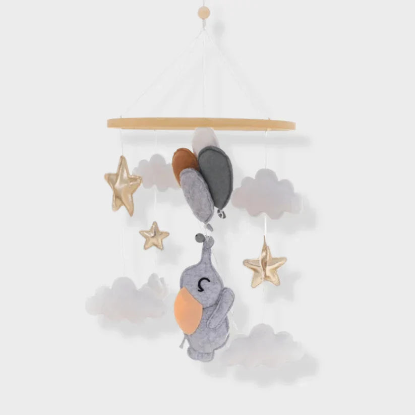 Wood-ring baby mobile with a gray elephant, cloud shapes, stars, and balloons