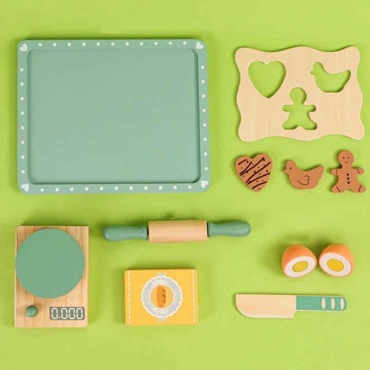 Eleven wooden baking play pieces arranged separately, including a tray, cookie shapes, scale and rolling pin