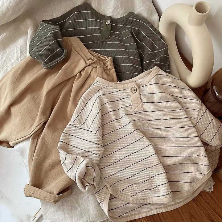 Green and light gray striped long-sleeve shirts styled with tan pants
