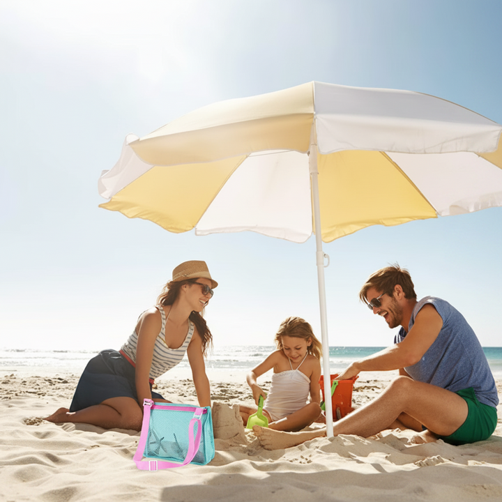 Family sitting under a beach umbrella beside a mint mesh bag with pink straps