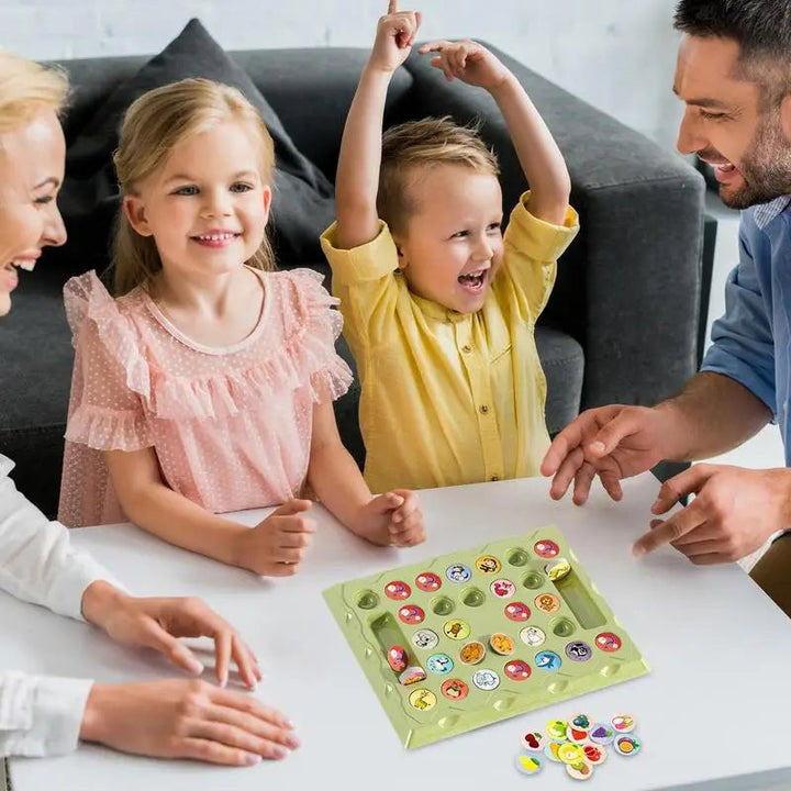 Two children and two adults gathered around the animal memory game at a table.