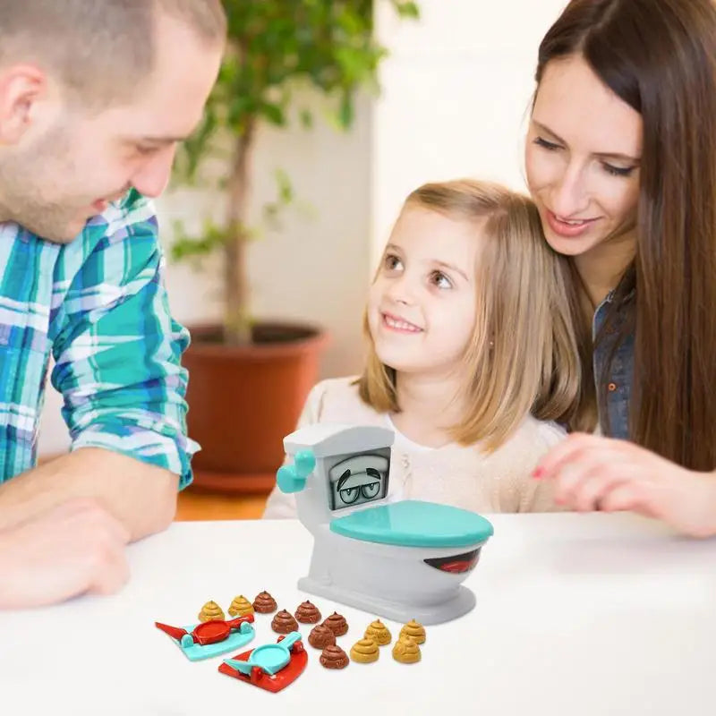 Parents and child gathered around the toilet catapult game on a table