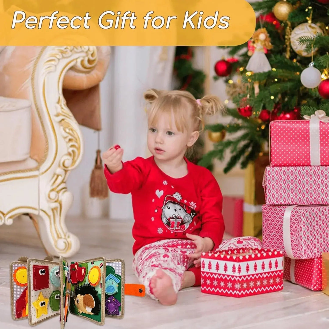 Child seated beside an open felt activity book, wrapped gifts, and a decorated tree