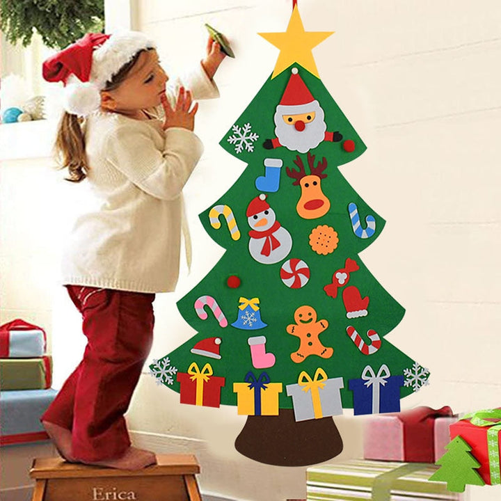 Child decorating a wall-hung green felt Christmas tree with colorful ornaments