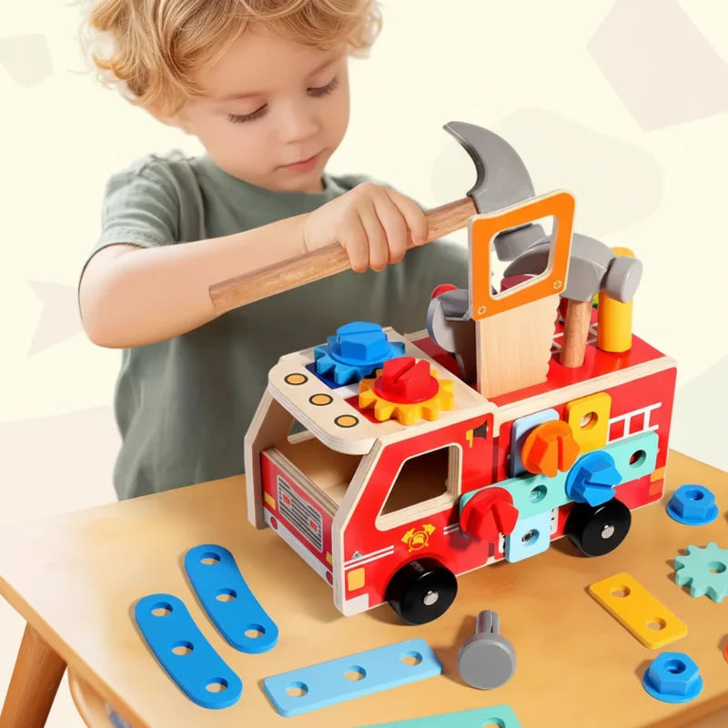 Child holding a wooden hammer over the fire truck building set.