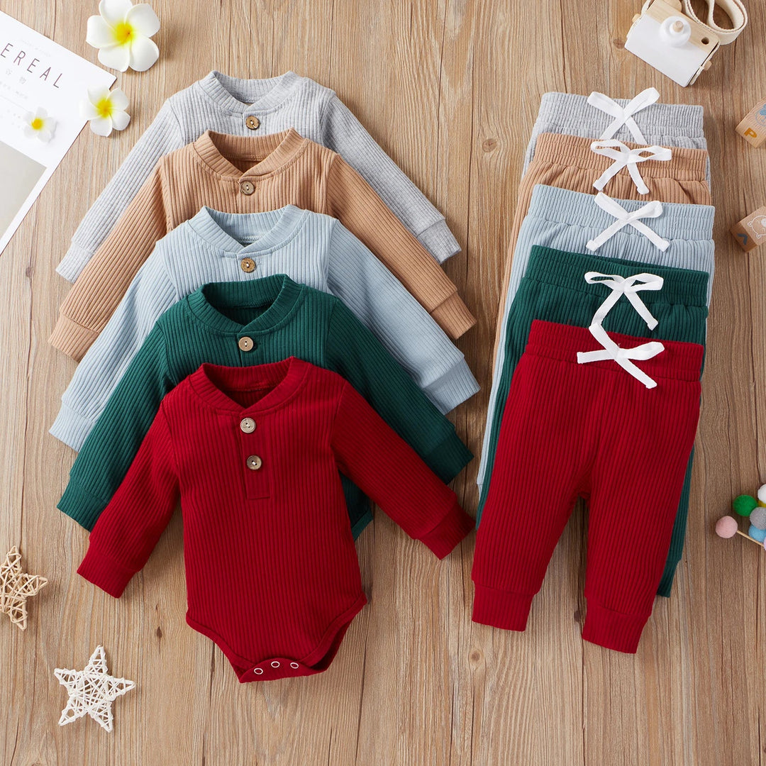 Five ribbed baby bodysuit and pants sets in gray, tan, pale blue, green, and red