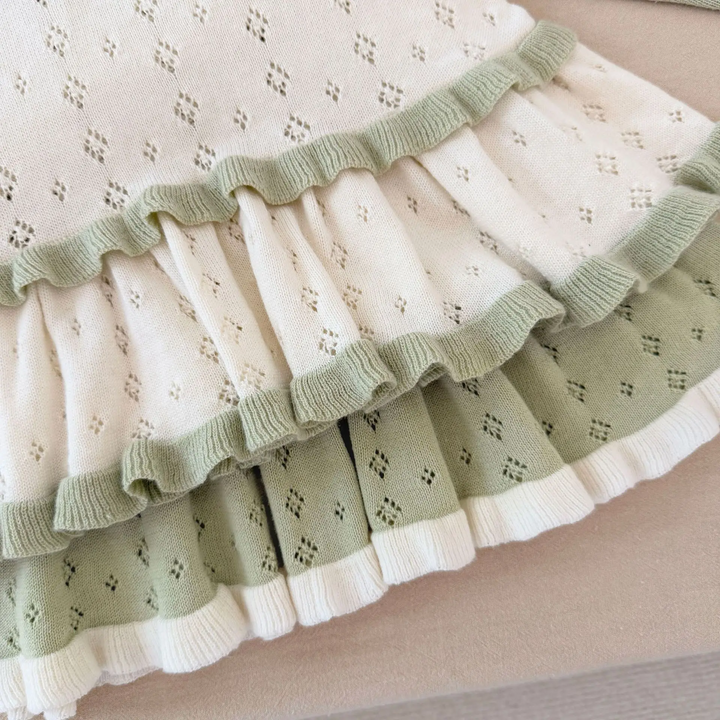 Flared skirt hems on white and green knit dresses with contrasting ruffle trim