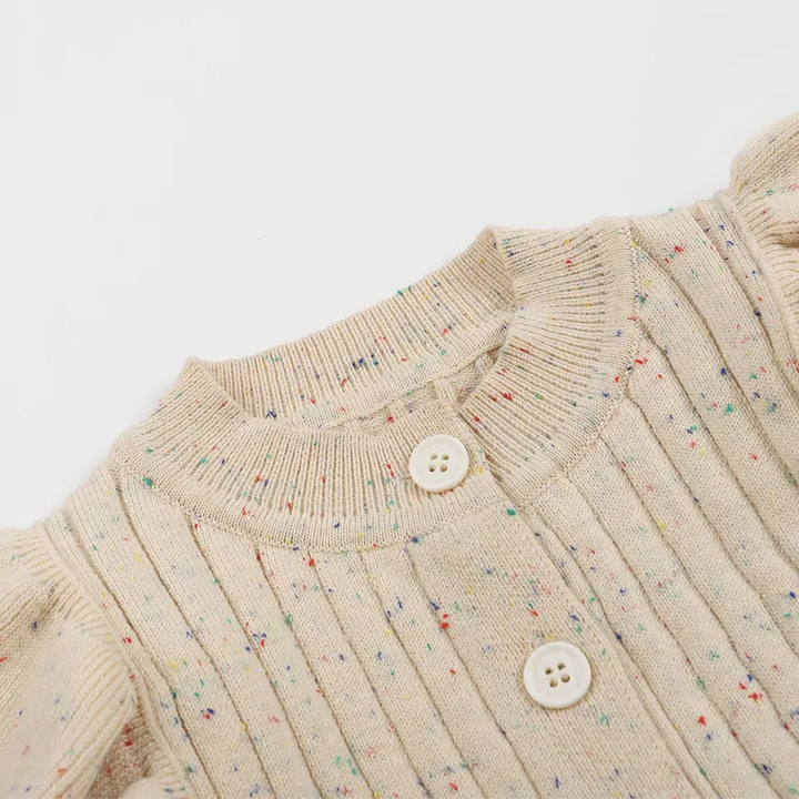 Close-up of the round neckline and front buttons on a flecked beige knit baby romper