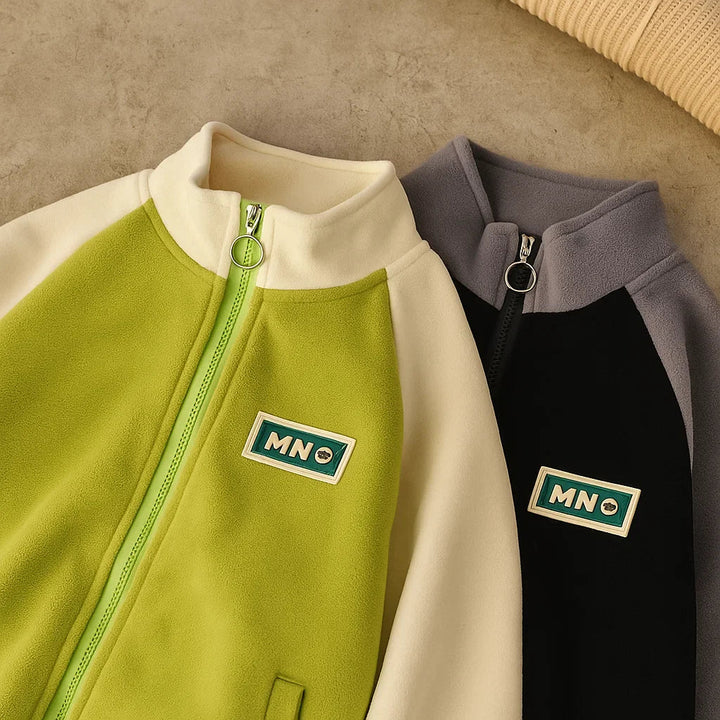 Close-up of two color-block fleece jackets with stand collars and full front zippers