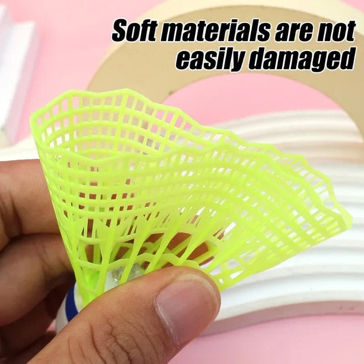 Hand squeezing the flexible green plastic skirt of a badminton shuttle