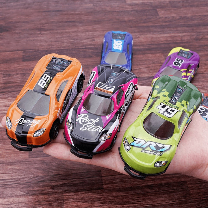Colorful stunt cars held in a hand, showing compact bodies and racing-style graphics
