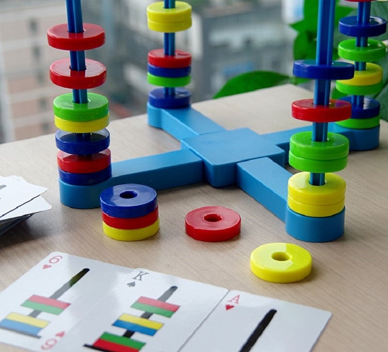 Close-up of stacked and floating colored rings on the board beside pattern cards