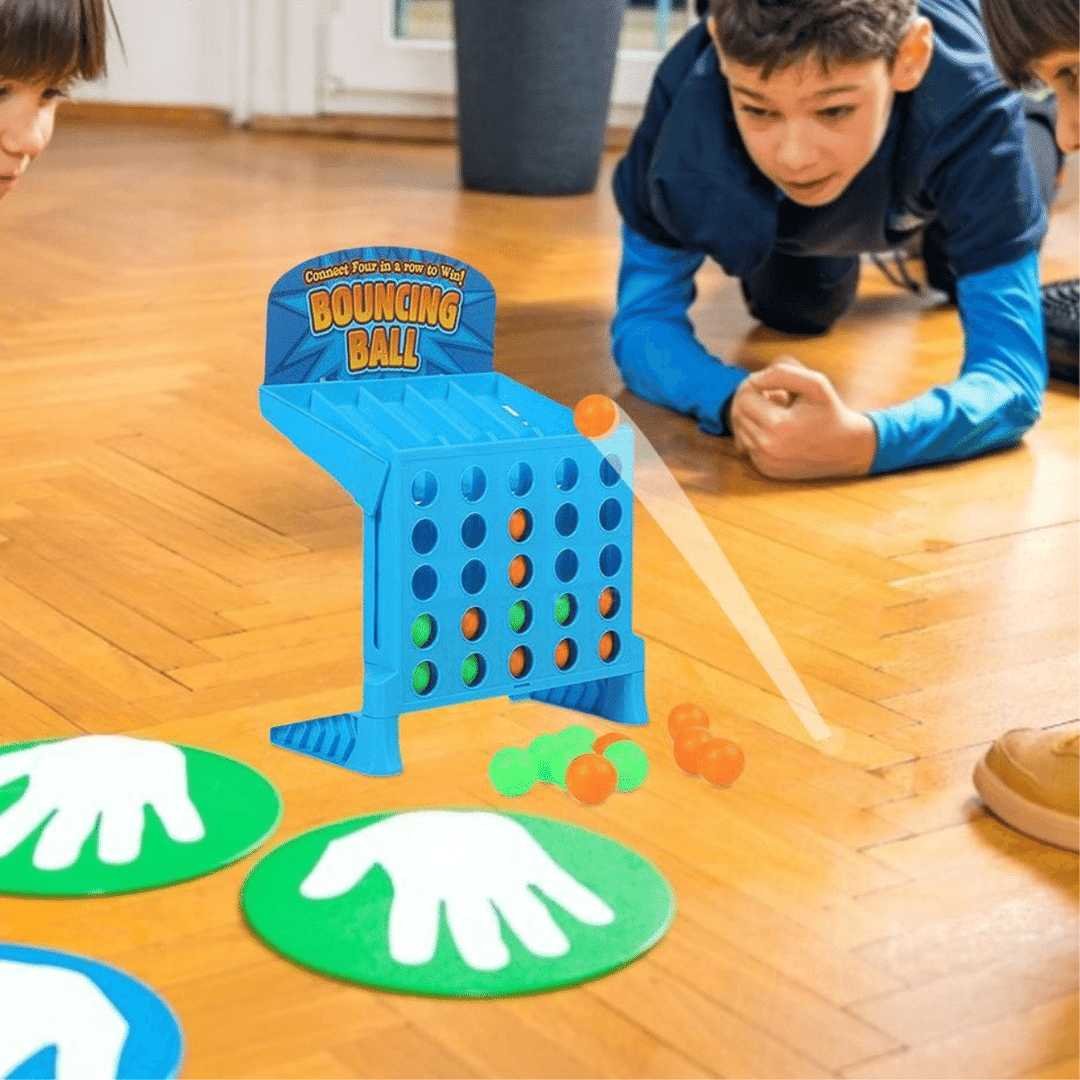 Child playing a blue four-in-a-row ball toss game on a wooden floor