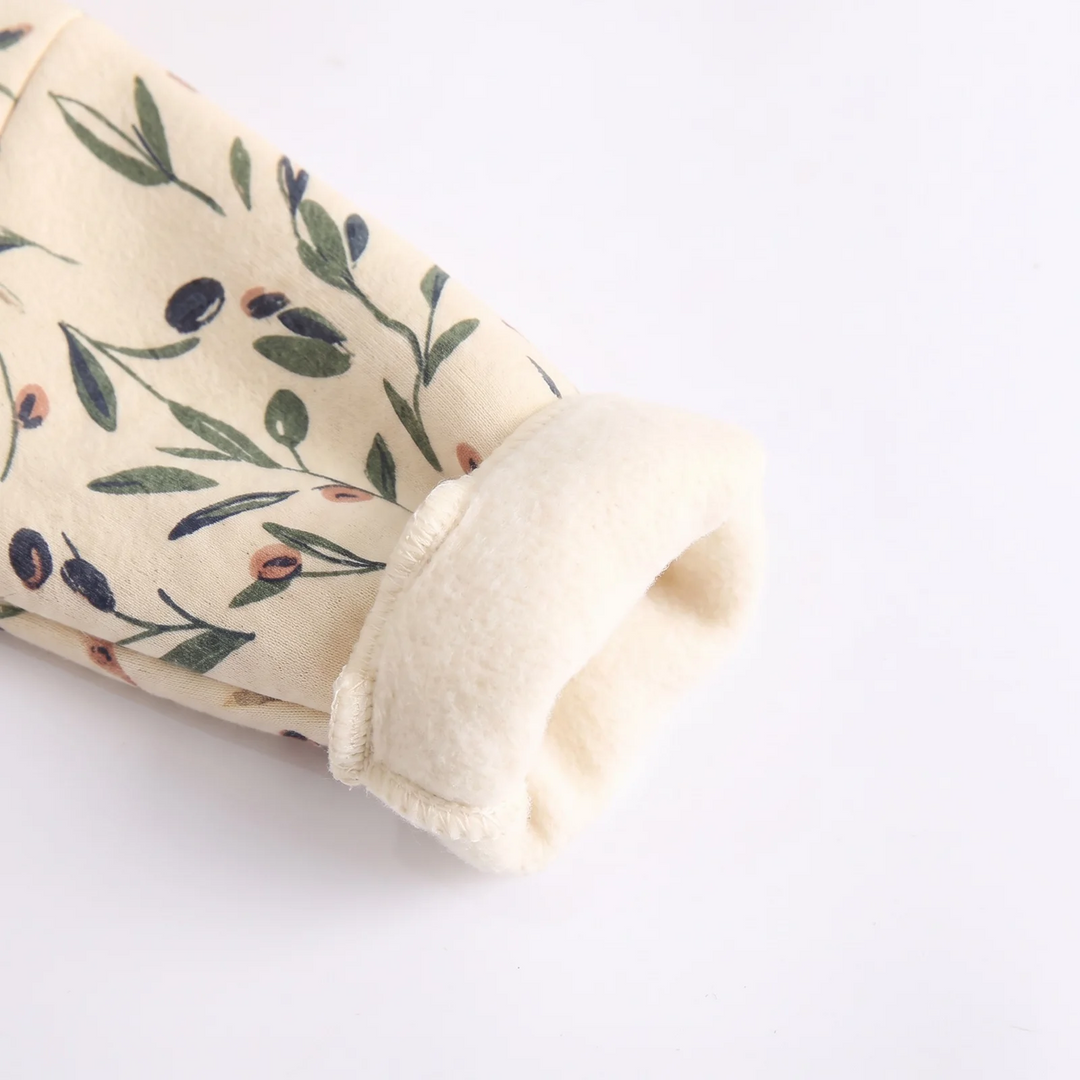 Turned-back cuff showing the cream interior of the floral baby romper.