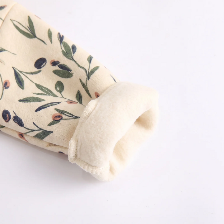 Turned-back cuff showing the cream interior of the floral baby romper.