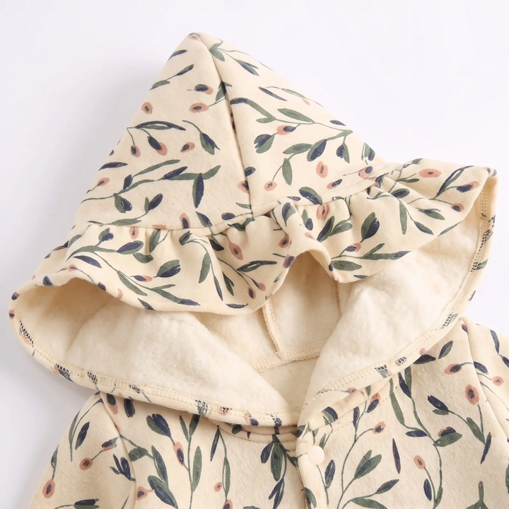 Close-up of the floral hood and cream-colored interior on the baby romper.