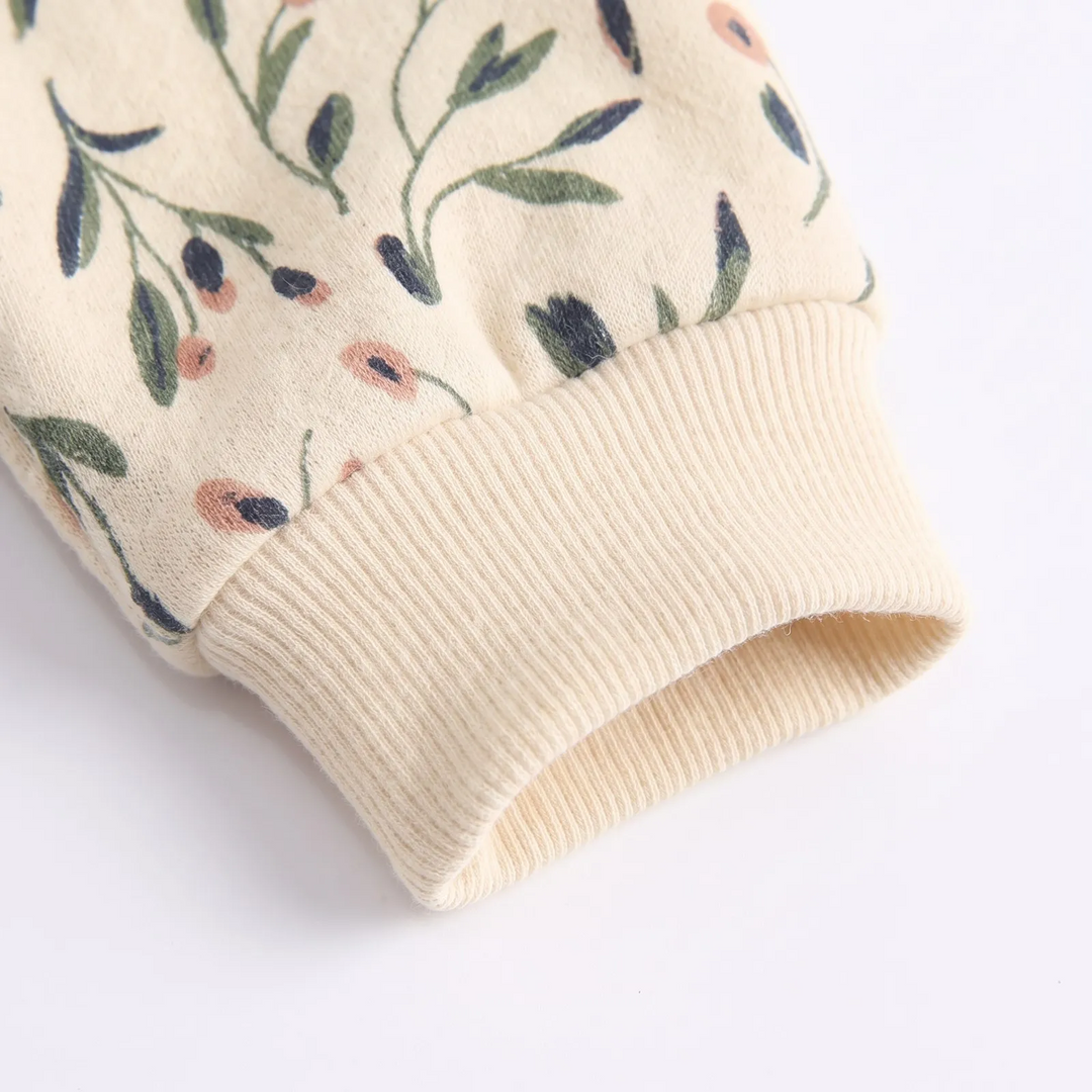 Ribbed cream sleeve cuff on the floral cotton baby romper.