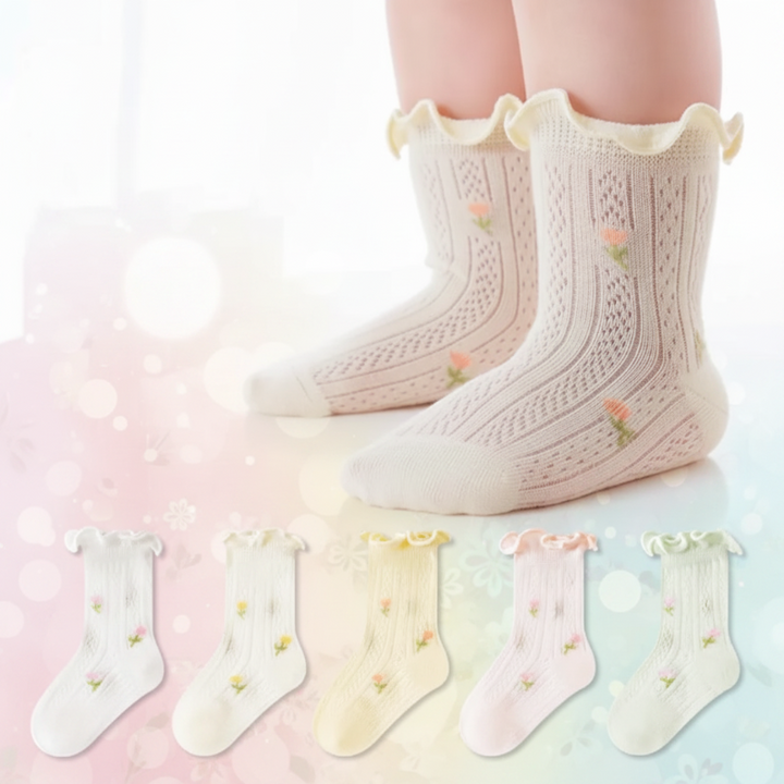 White pointelle baby socks worn on feet, with five pastel color options shown below.