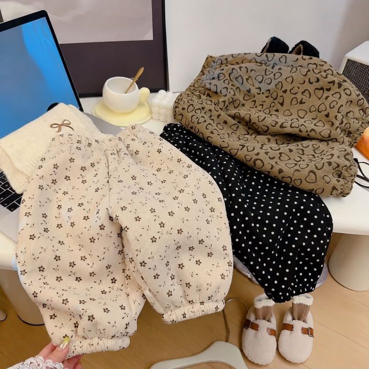 White floral, black polka-dot, and brown heart pants arranged together
