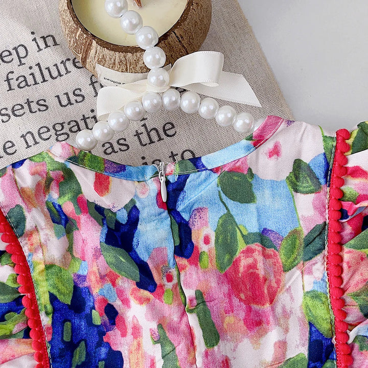 Back view of the floral dress bodice with red trim and ruffled shoulders