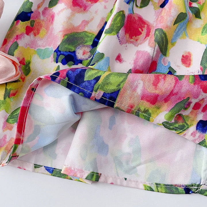 Close-up of the floral dress hem showing the folded edge and reverse side of the fabric